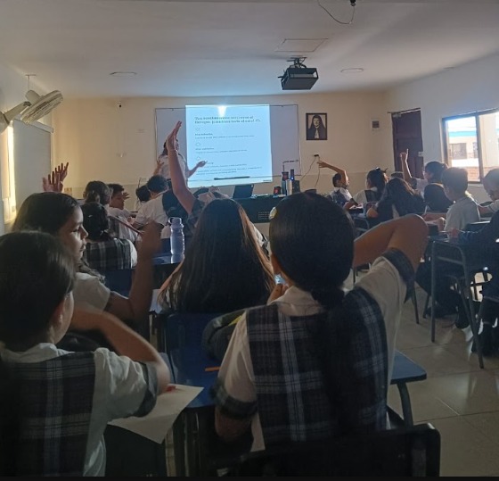Estudiantes participando activamente en clase con apoyo audiovisual